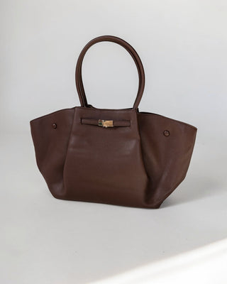 Brown handbag with a gold clasp on a light gray background