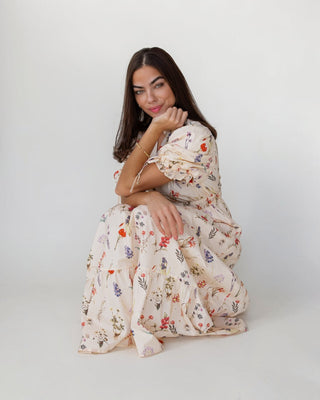 Woman wearing a floral dress sitting on a white background
