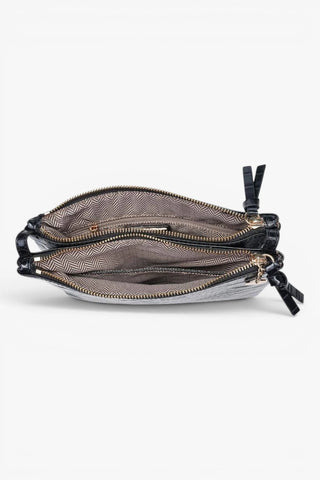 Interior view of black croc texture crossbody bag showing fabric lining, zip pocket and organized compartments