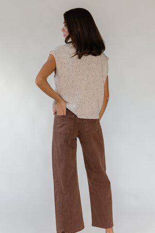 A woman shown from the back wearing a sleeveless textured knit top in a light beige speckled pattern and brown wide-leg pants, standing against a plain light gray background.