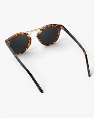 Sunglasses with tortoiseshell frame and dark lenses on a white background