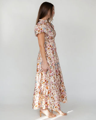 JO+CO Britton floral maxi dress in ecru with a tiered skirt, elasticized waist, and notched V-neck. Made of cotton.